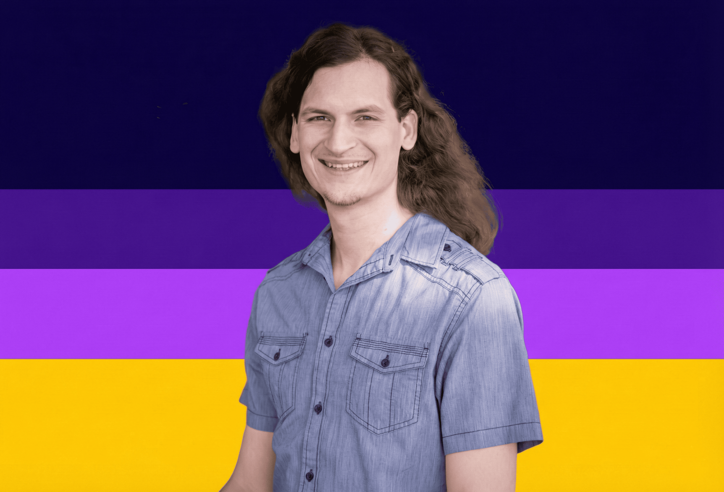 A smiling man with long, wavy hair standing against a vibrant, colorful background.